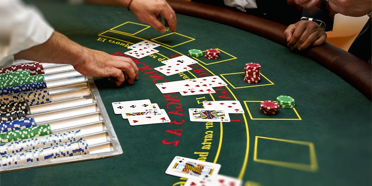 Dealer and players at blackjack table.