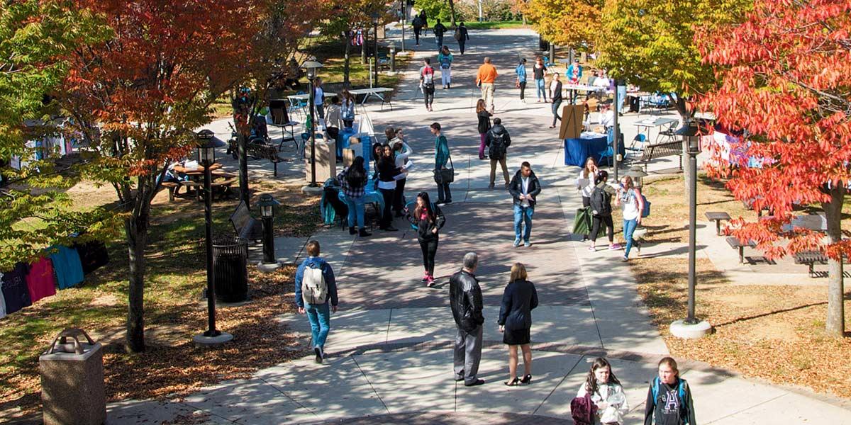 Students walk across the quad in autumn.